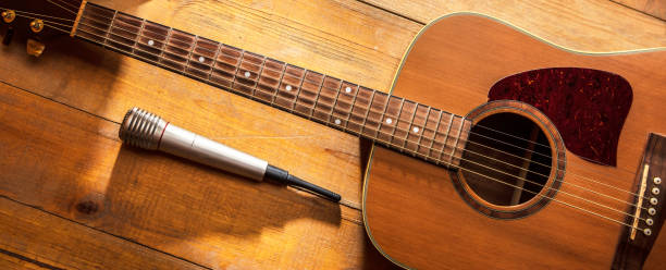 istock Acoustic guitar with a microphone on a wooden background 2185638543