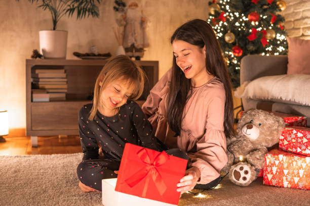 istock Two cheerful girls open Christmas gift 2185640770