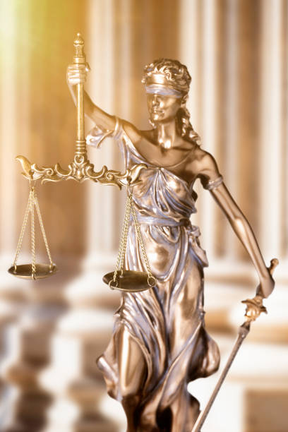 istock Lady Justice in front of courthouse columns with sunflare 2185641309