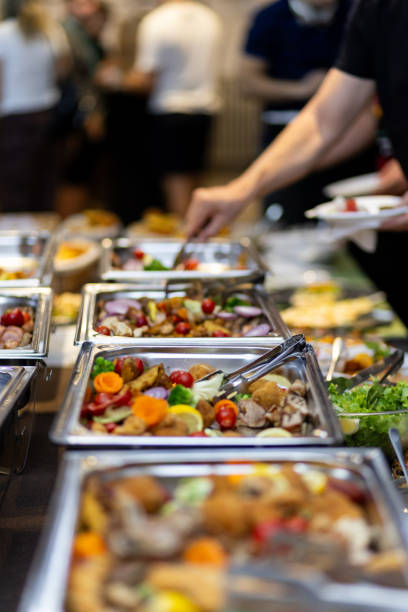 istock Culinary feast served at a buffet with diverse dishes and guests enjoying their meals at a festive gathering 2185642148