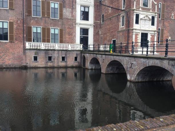istock Arched bridge across a canal, leading to a building. 2185644212