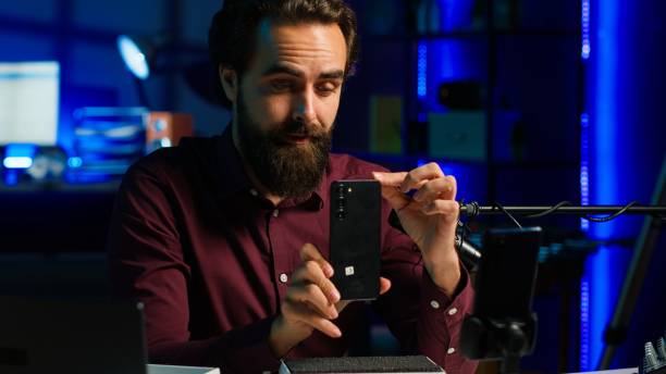 istock Media star in neon lit studio presents cellphone from brand sponsoring video 2185645871