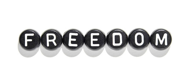 istock Freedom concept: black and white alphabet beads spelling 'freedom' against white 2185646446