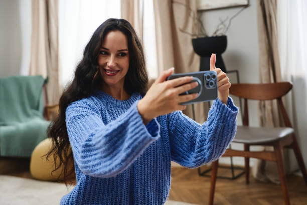 istock Young woman taking a selfie in a cozy indoor setting during daylight hours 2185647380