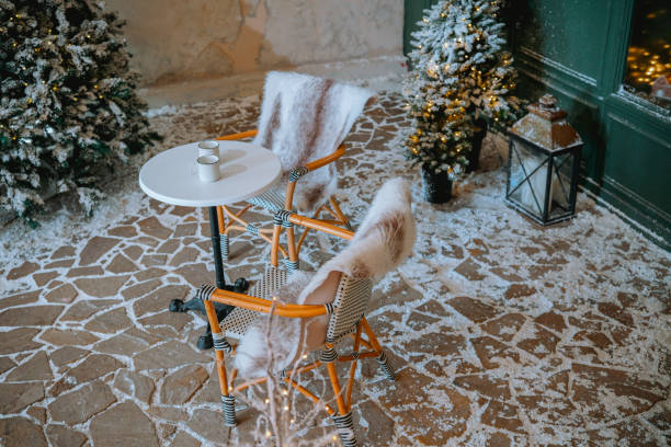 istock Winter outdoor seating area with snowy decor and warm beverage on a table 2185647648