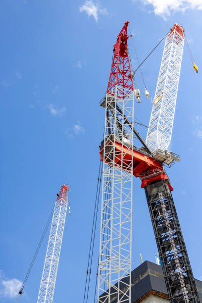 istock Low angle view of two tower cranes at construction site, background with copy space 2185647816