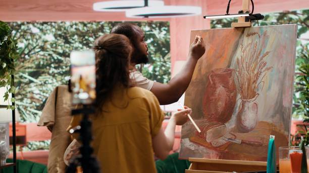 istock Artists recording creative process of painting an artwork piece 2185650753