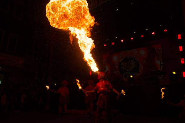 A man in a chemical protection suit and a gas mask plays with fire.As a state-level intangible cultural heritage in China, Huohu (fire pot) is a traditional folk performance art. Performers put well-burned charcoal into iron meshes on both sides and shake the meshes up and down so that the charcoal will flare up and blazing sparks will burst out of the meshes and light up the sky just like fireworks. The performance is not only to show the traditional stunt thousands of years’ old, but also to create a lively festival mood, hailing for good fortune and fencing off evil spirits. Nowadays, the Huohu performance has evolved into a popular folk entertainment, drawing people close with both the visible flames and the invisible passion and carrying on people’s wish for a happy life.