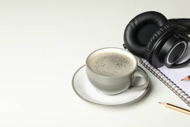 istock A cup of coffee with headphones and a notebook on a light background 2185660529
