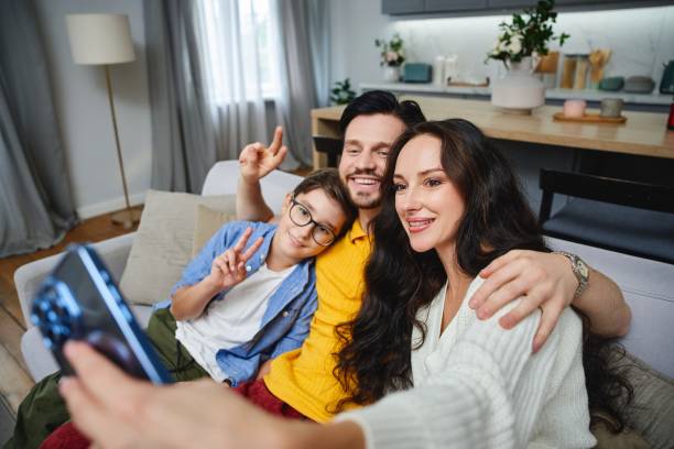 istock Family enjoys a joyful moment while taking a selfie at home 2185662804