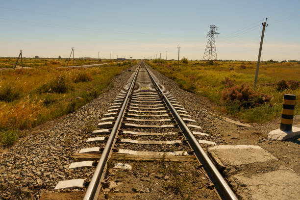 A long railroad track with a few trees in the background in Urgench, Xorazm Region, Uzbekistan