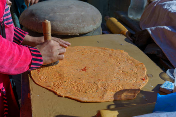 A person is making a pizza with a wooden tool in Khiva, Xorazm Region, Uzbekistan