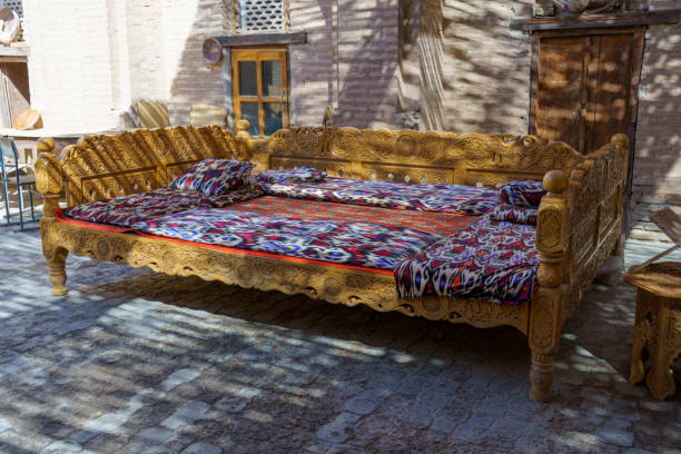 istock A long wooden bed with a colorful blanket and pillows 2185663975