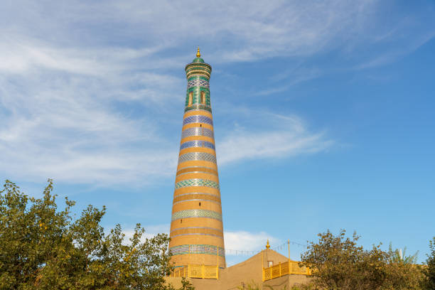 A tall building with a green roof and a blue stripe in Khiva, Xorazm Region, Uzbekistan