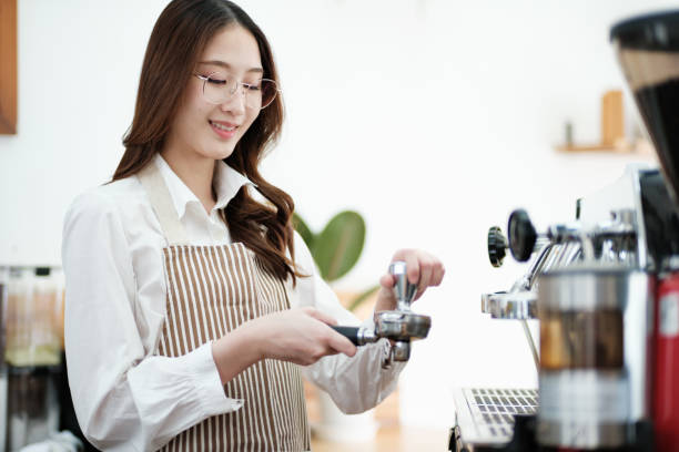 istock Barista tamping espresso grounds, showcasing precision and professionalism in a cafe setting. 2185664258