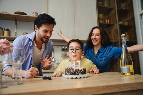 istock Celebrating a childs birthday with cake, candles, and joyful parents at home 2185664708