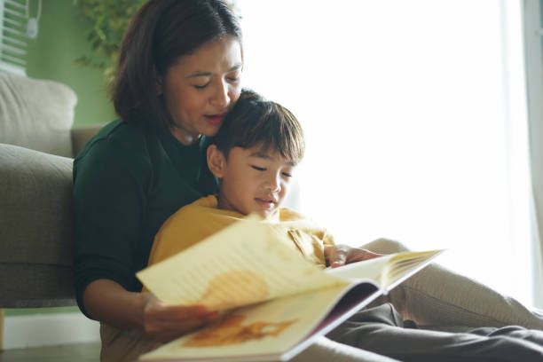 istock Mother reads a book with her son on the sofa 2185668493