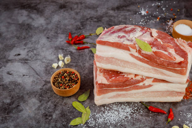 istock Freshly cut pork belly with spices and herbs on textured background ready for culinary preparation 2185670807