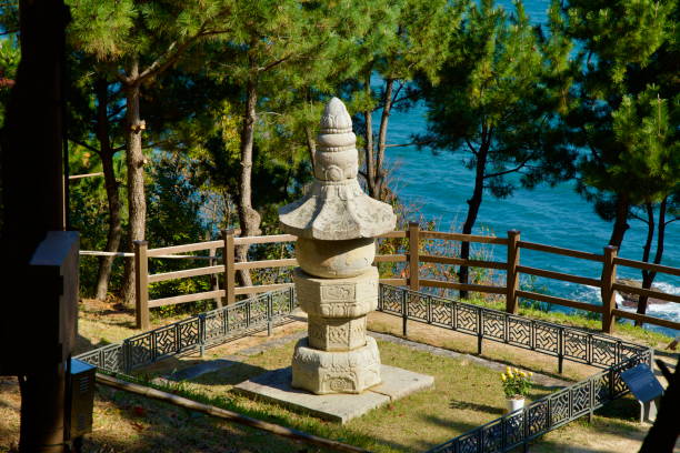Yangyang County, South Korea - November 3rd, 2024: The Seawater Avalokitevara Stupa stands serenely near the East Sea at Naksansa Temple, framed by pine trees and surrounded by a traditional fence.