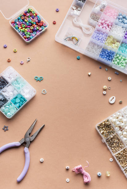 istock Crafting with colorful beads on a flat workspace with tools and containers in bright daylight 2185677001