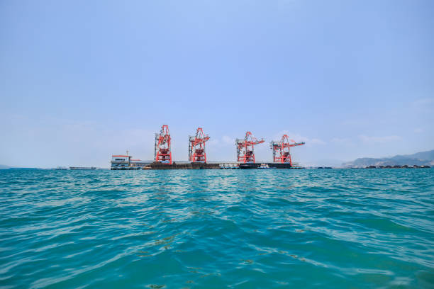 istock Industrial Crane Unloading Coal from a Barge for Power Plant Operations.Barge and Crane Operation for Coal Distribution to Power Plants 2185678804