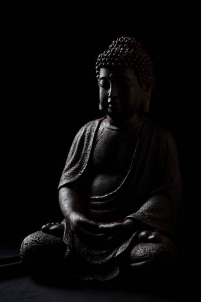 istock Meditating Buddha Statue on dark background. Close up. Copy space. 2185682082