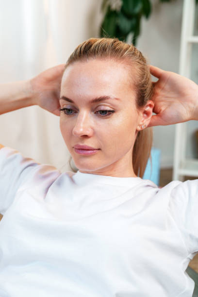 istock Woman performing a stretching exercise in a bright indoor 2185682609