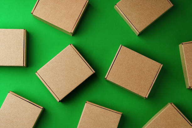 istock Brown cardboard boxes arranged on a vibrant green surface 2185683391