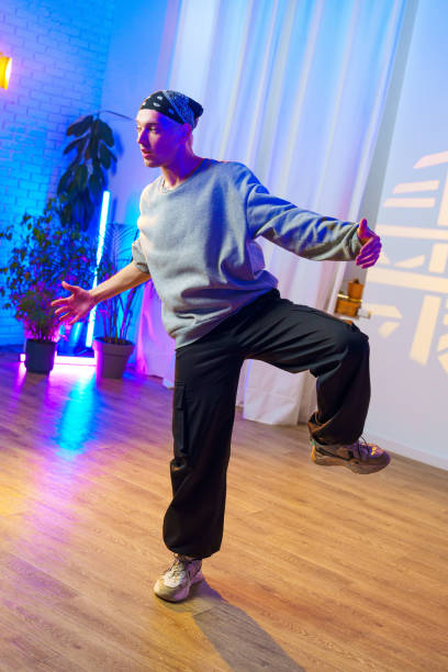 istock A dancer poses in a studio with blue and purple lights 2185683646
