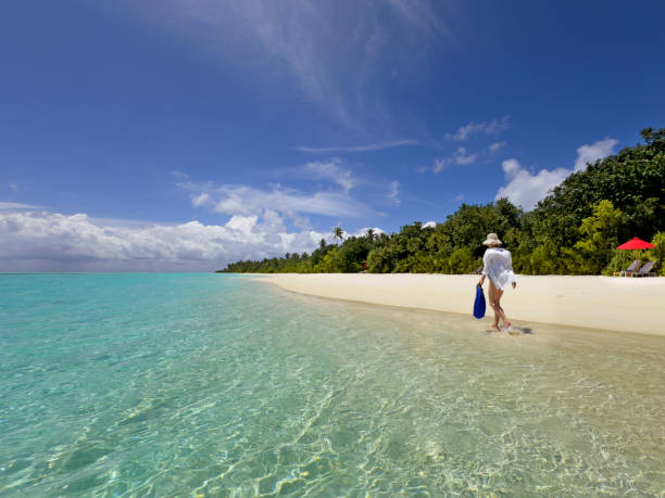 istock Woman walks along tropical beach 2185684935