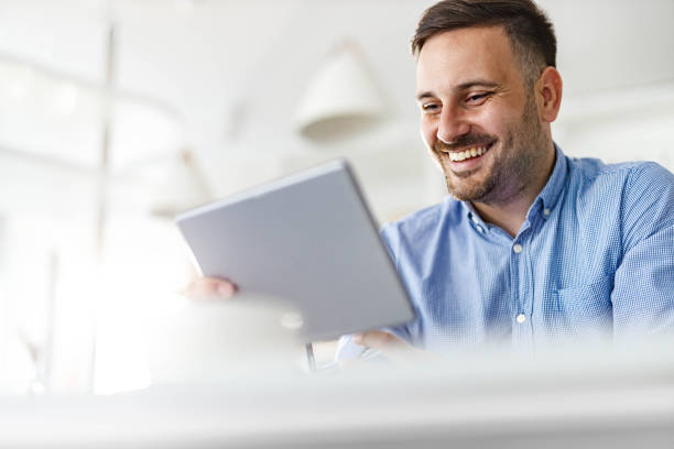 istock Happy man having a video call over touchpad at home office. 2185687819