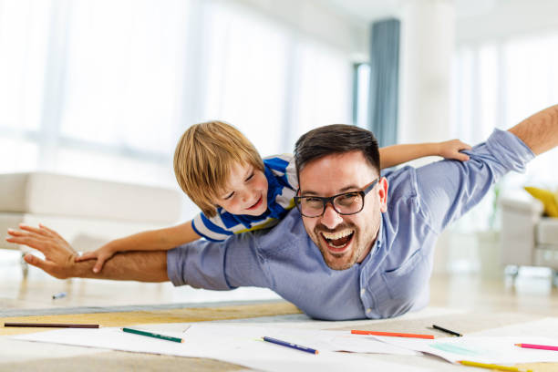 istock Playful single father and son having fun on floor at home. 2185688060