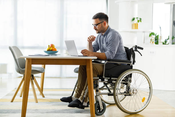 istock Disabled businessman working on laptop at home. 2185688117