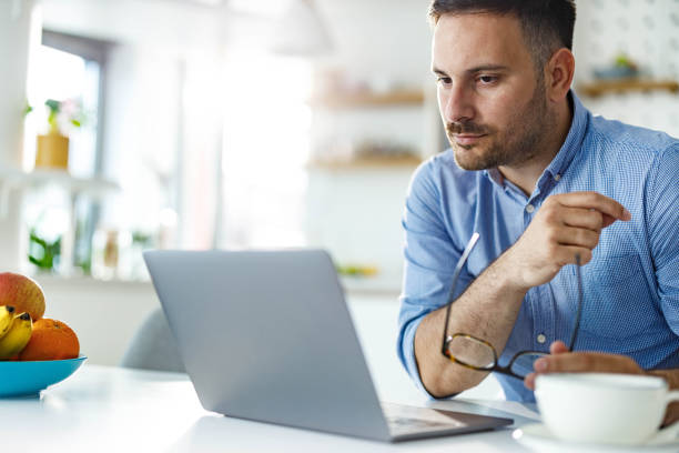 istock Serious businessman reading an e-mail on laptop at home. 2185688241