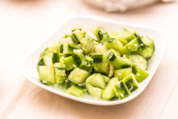 Sliced cucumbers. Fresh cucumber salad with herbs close-up. Soft focus