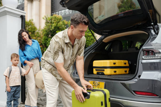 istock Unloading Luggage from Open Trunk Beside Family Members 2185690423