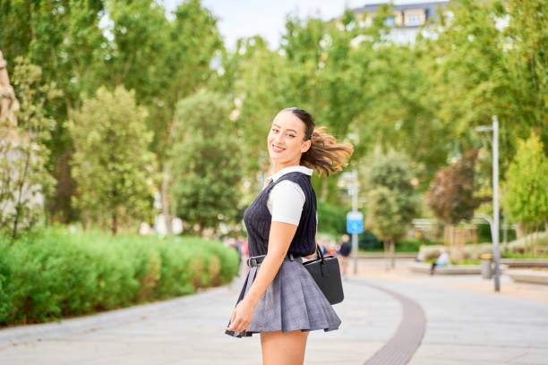 istock Smiling woman twirling in a park with greenery 2185691176