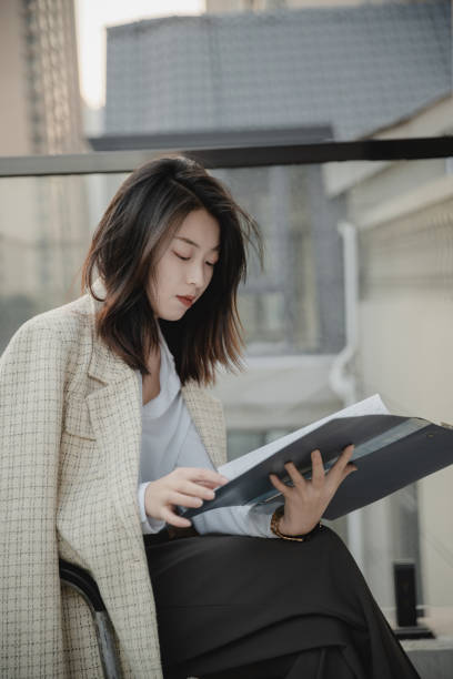 istock Asian female white-collar workers read papers in the open office area 2185694706