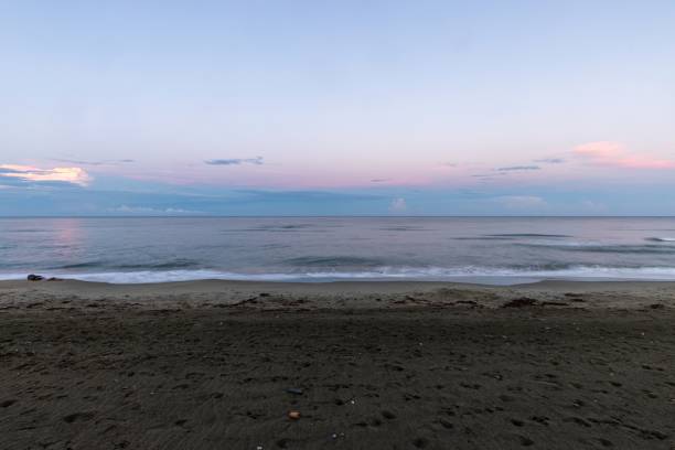 istock Serene beach at sunset with soft pink skies and sandy shore in evening light 2185695104
