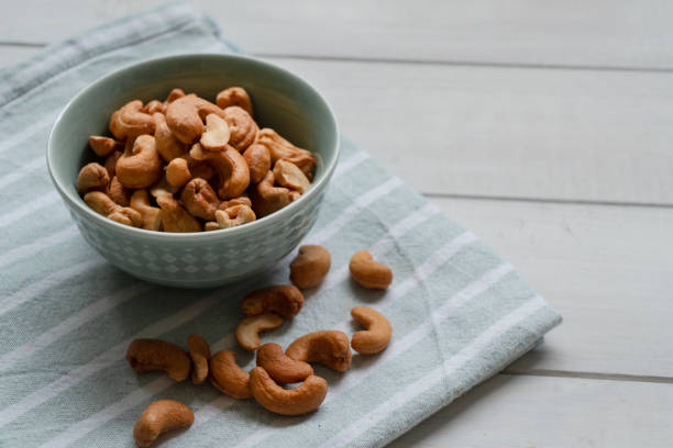 Cashew nuts in bowl on wood