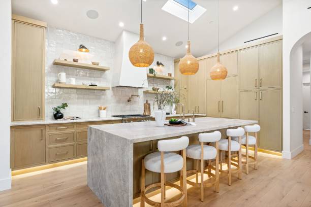 istock Modern kitchen with wooden cabinets and pendant lights. 2185699039