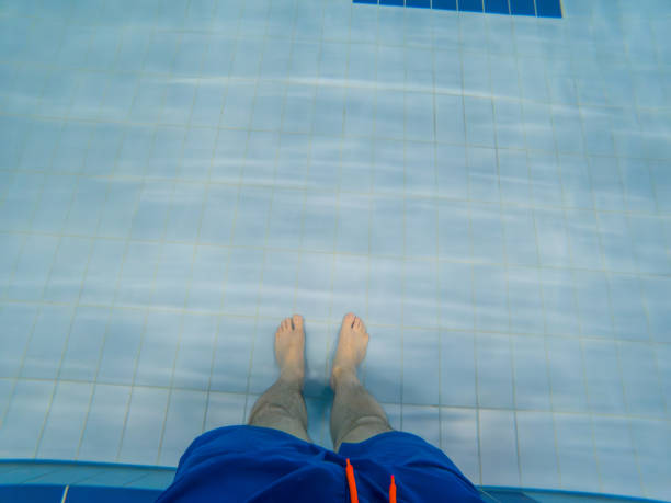 Person Standing in Pool with Blue Swim Trunks copy space