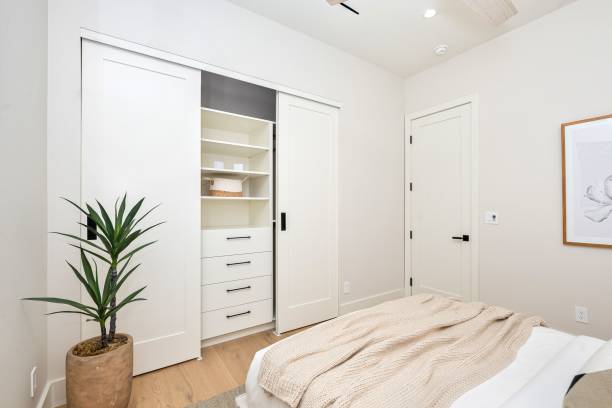 istock Minimalist bedroom with open closet and plant. 2185699169