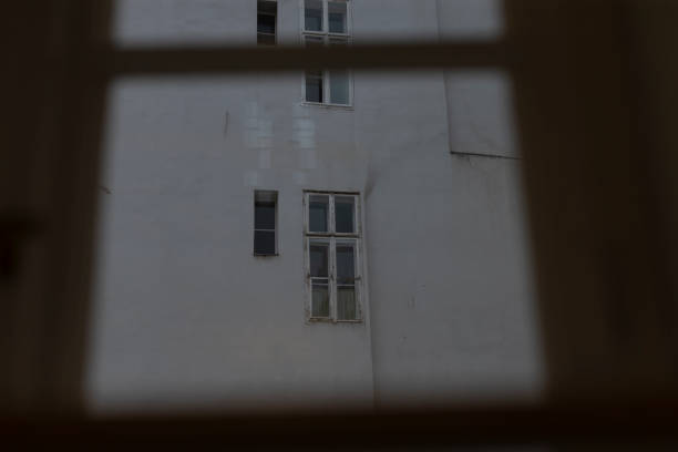 istock Photograph of a Gray Building Facade Featuring Windows Taken Through a Window 2185701367