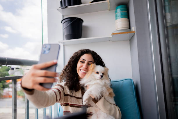 istock Young woman taking a selfie with dog on balcony 2185701840