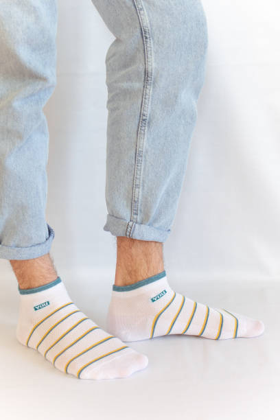 istock Men's legs in jeans and light-colored socks 2185702584