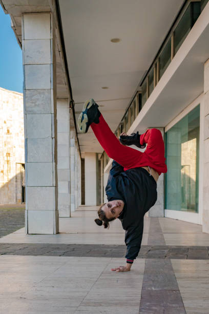 istock A young man in black sweatshirt and red pants breakdancing on a sidewalk. Space to write 2185703197