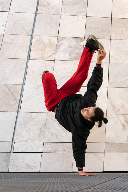 istock A young man in red pants performs a breakdance pose on a metal grate 2185703198