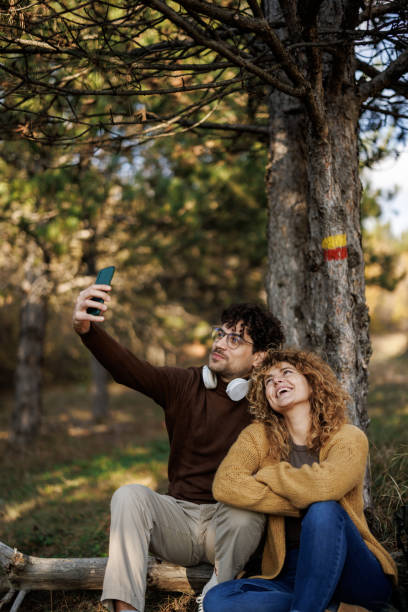 istock Happy couple taking selfie in sunny woods 2185703284