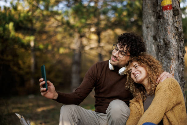 istock Happy couple taking selfie in sunny woods 2185703292